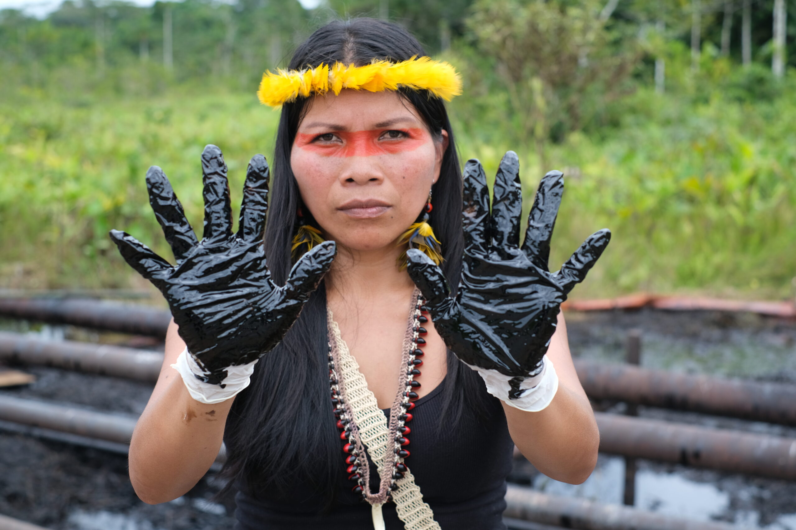 Waorani Leader Nemonte Nenquimo shows evidence of crude oil contamination after an oil spill affecting waterways in the northern Ecuadorian Amazon. Photo Sophie Pinchetti / Amazon Frontlines 
